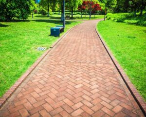 a brick walkway in a city park.