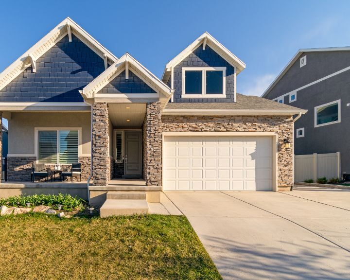 A city home featuring blue siding, a garage, and a concrete driveway.