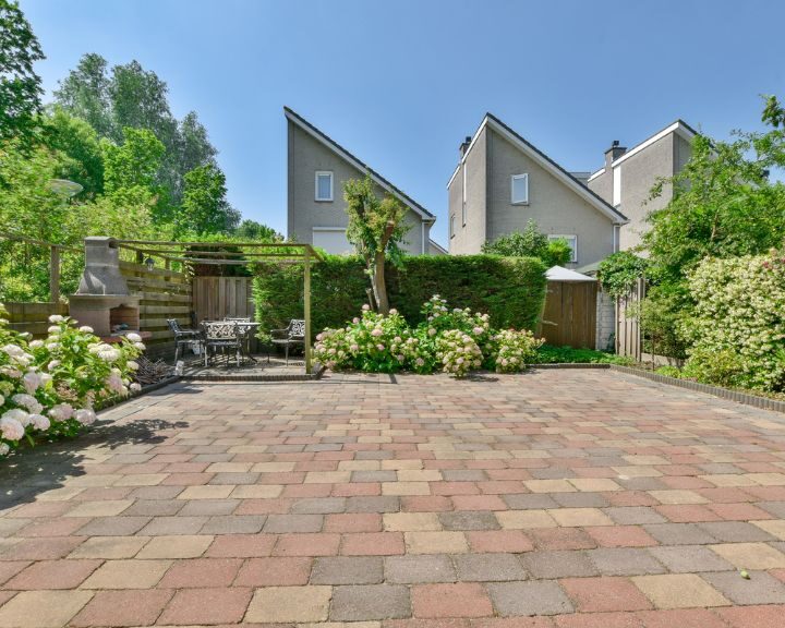 A city backyard with brick pavers and flowers.