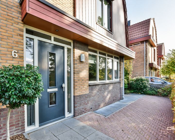 a house with a blue door and a brick walkway in the city.