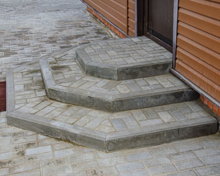 A set of stamped concrete steps leading up to a city house.