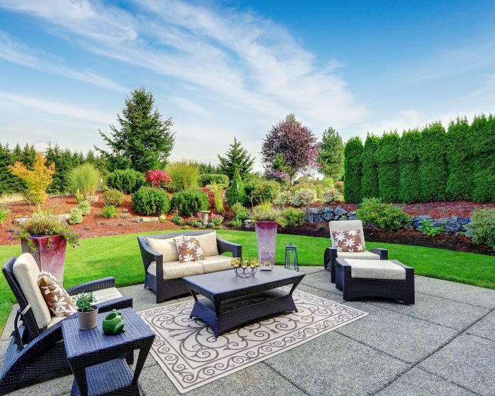 A beautifully landscaped backyard with concrete patios in the city.