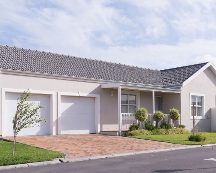 a city house with two garages and a concrete driveway.