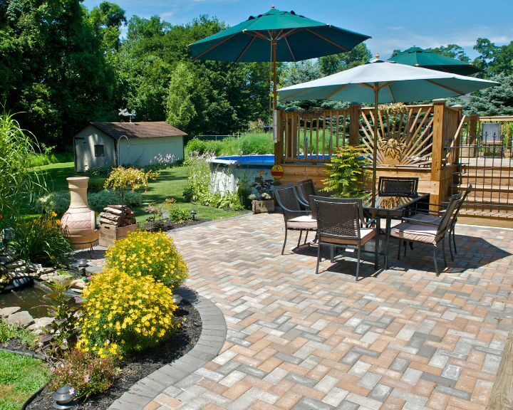 A city backyard patio furnished with concrete, an umbrella, and patio furniture.